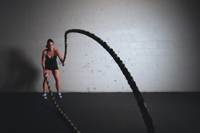 A woman training with a heavy rope in a gym